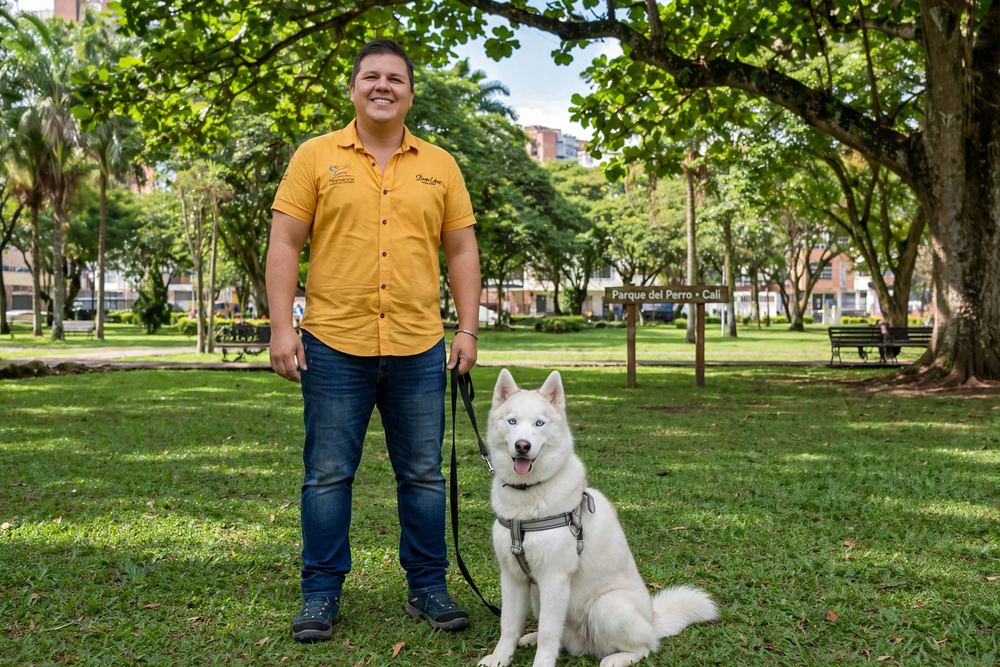 Stiven López, etólogo canino de Huellas, con un husky obediente en el Parque del Perro de Cali